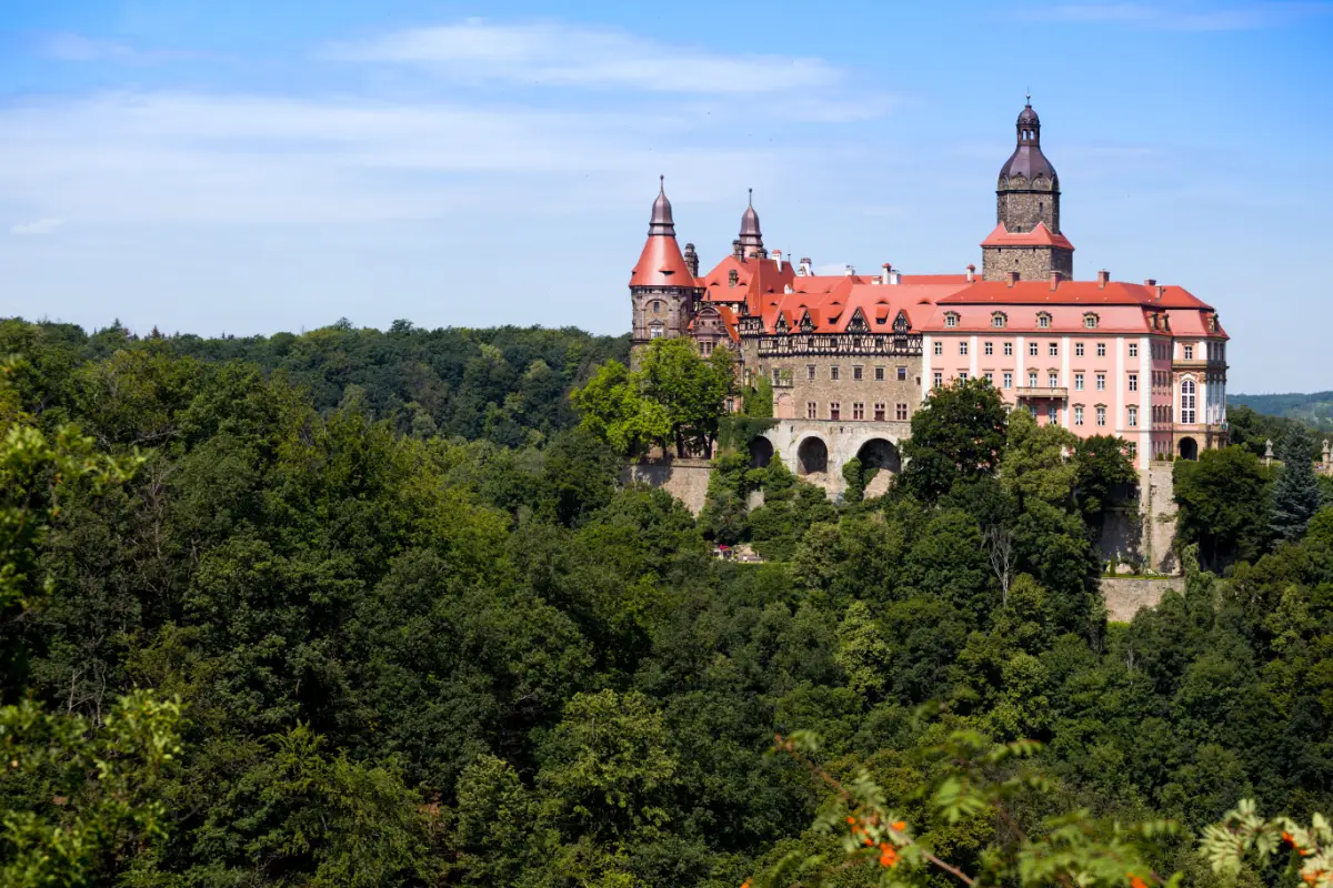 Monumentalna bryła zamku górująca nad zalesionym wzgórzem w pobliżu Wałbrzycha, Zamek Książ i jego niezwykła architektura łącząca średniowieczną warownię z barokową rezydencją